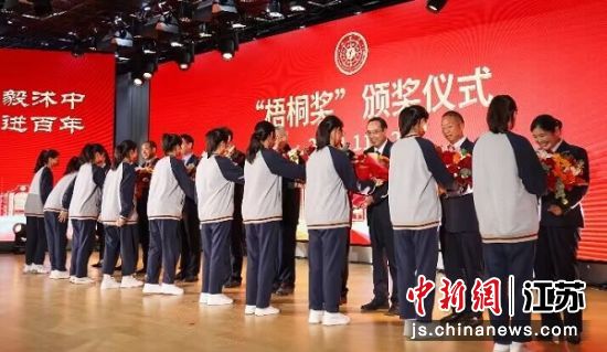 同学们向首届“梧桐奖”获奖老教师代表献花。沭阳县委宣传部供图