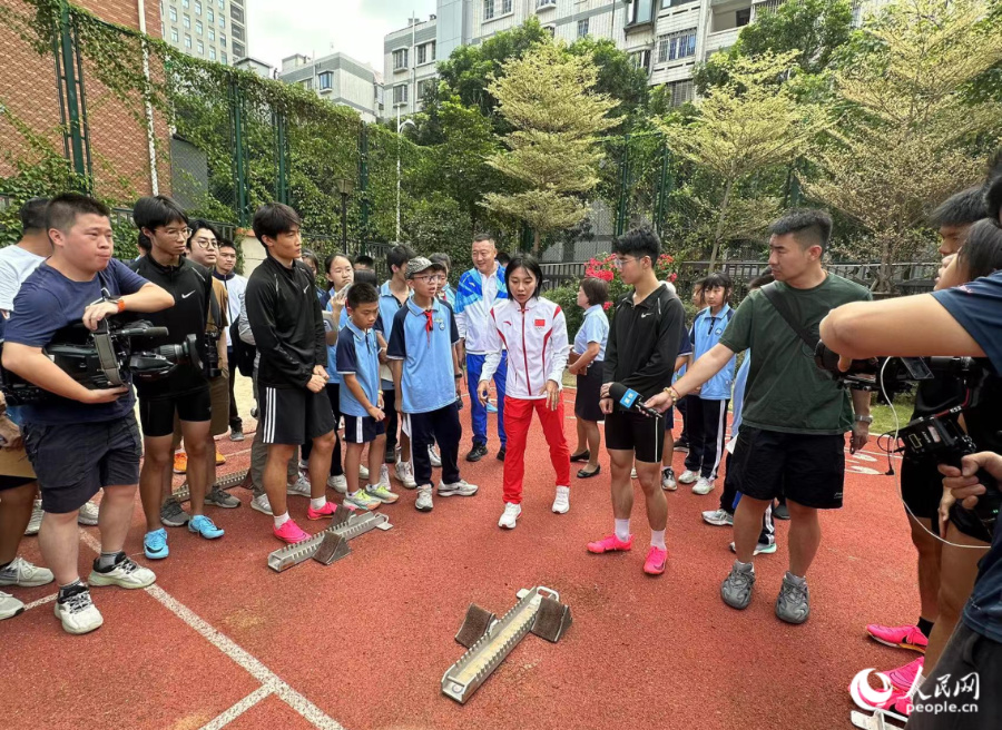 葛曼棋对学弟学妹们的起跑姿势及动作要领等进行指导。人民网记者 张萌摄